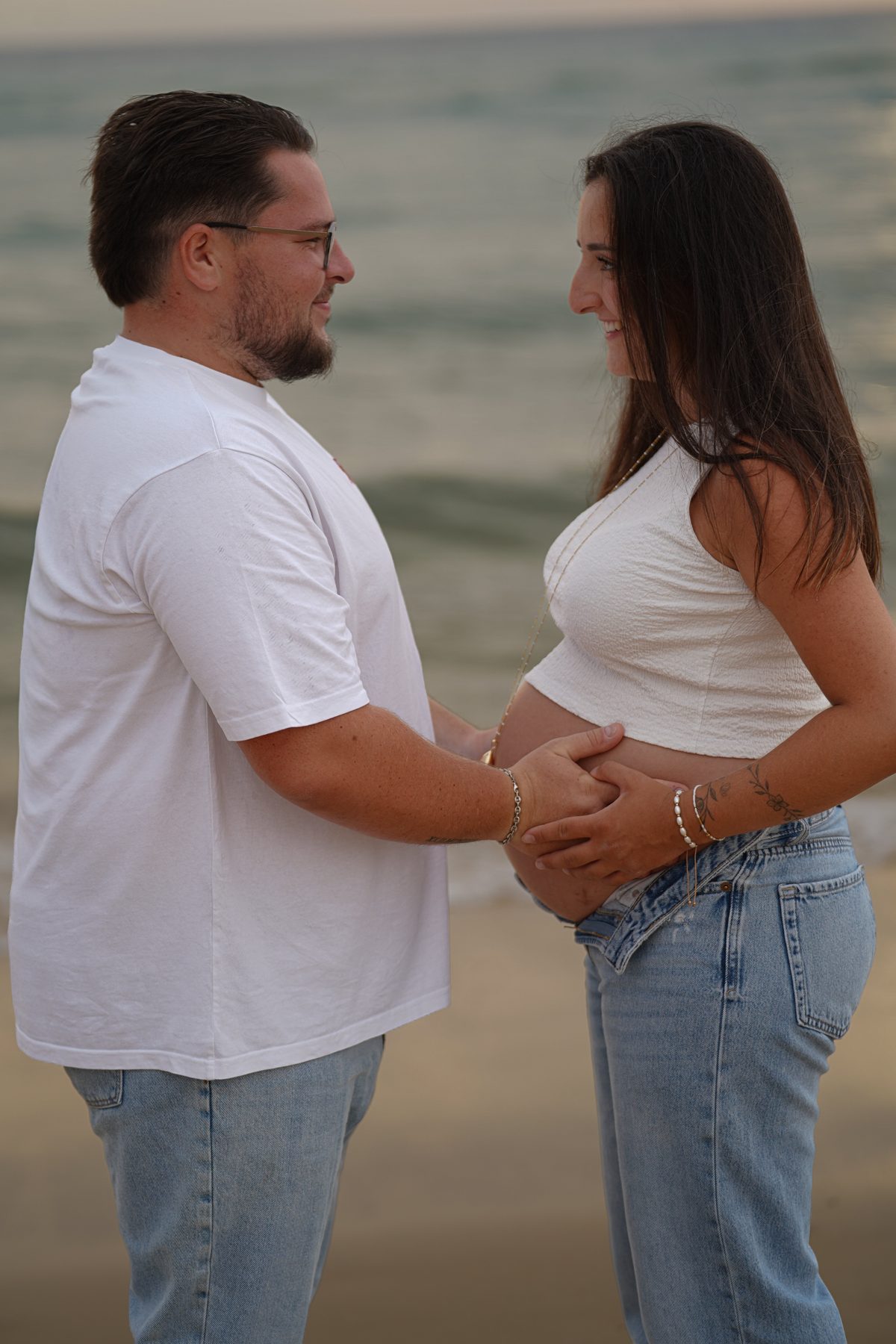 Shooting grossesse Noémie et Romain – les mains réunies sur le ventre arrondi
