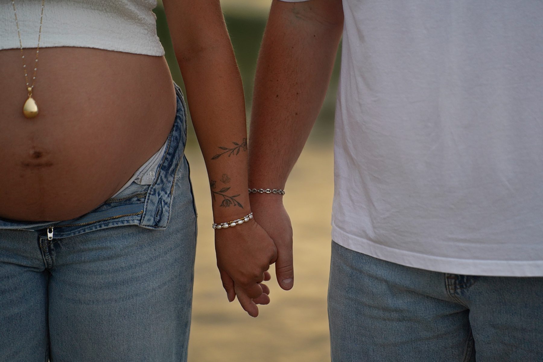 Shooting grossesse Noémie et Romain – détail des mains liées et du ventre